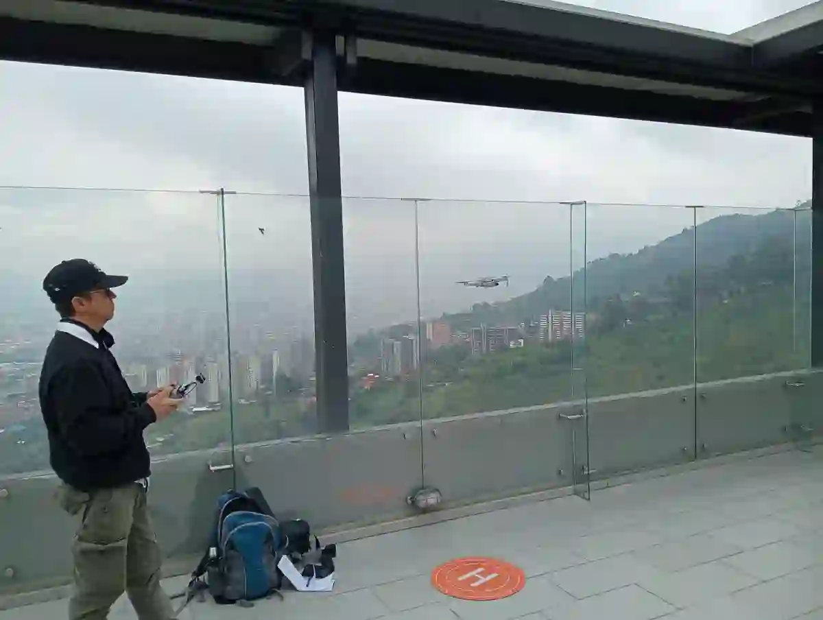 Piloto operando un dron desde una terraza con vista al valle de Aburrá
